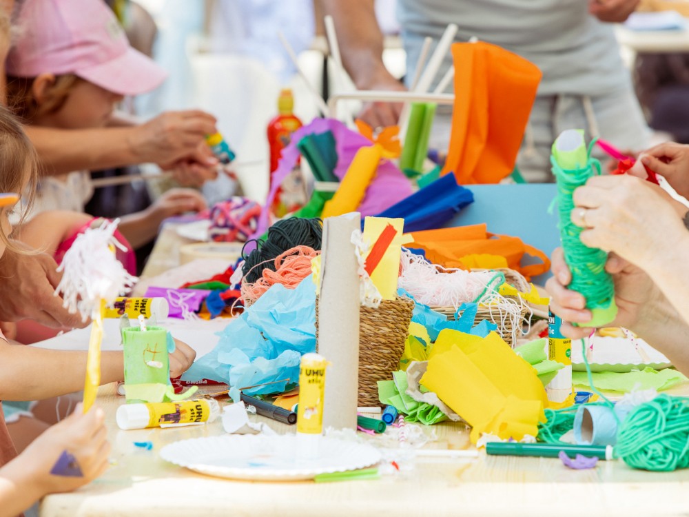 Kinder basteln an einer kreativen Bastelstation des Kinderfests im Waldmüllerpark. 