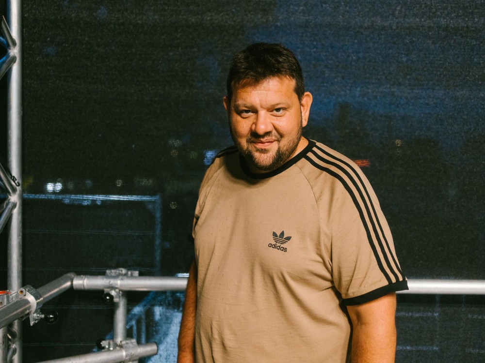 Petar Rosandić aka Kid Pex ist Kurator für Rap & Pop beim Kultursommer Wien 2026. Er steht auf einer der Kultursommer-Bühnen und lächelt. 