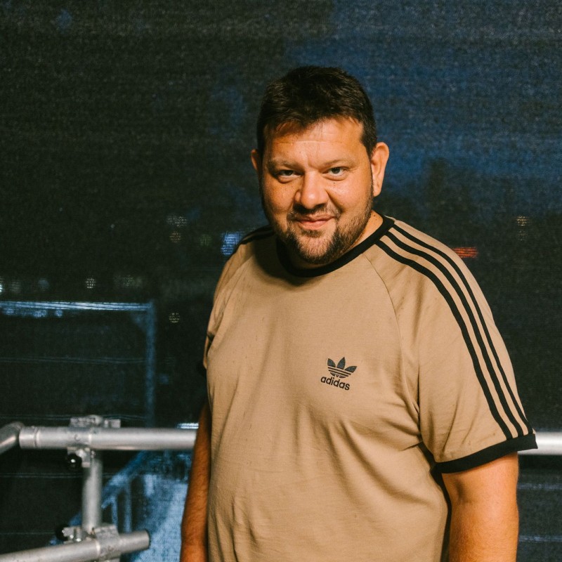 Petar Rosandić aka Kid Pex ist Kurator für Rap & Pop beim Kultursommer Wien 2026. Er steht auf einer der Kultursommer-Bühnen und lächelt. 