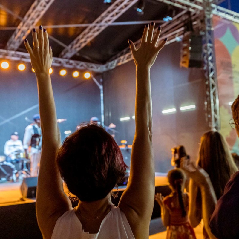 Foto: Judith Stehlik Eine Person streckt die Arme über den Kopf. Es spielt die Kuare Salsa Band auf der Kultursommer-Bühne am Nordwestbahnhof.