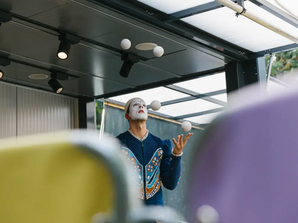 Ralph Öllinger jongliert als Clown verkleidet.